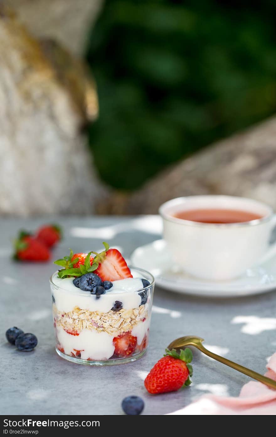 Granola in glass with berries and tea