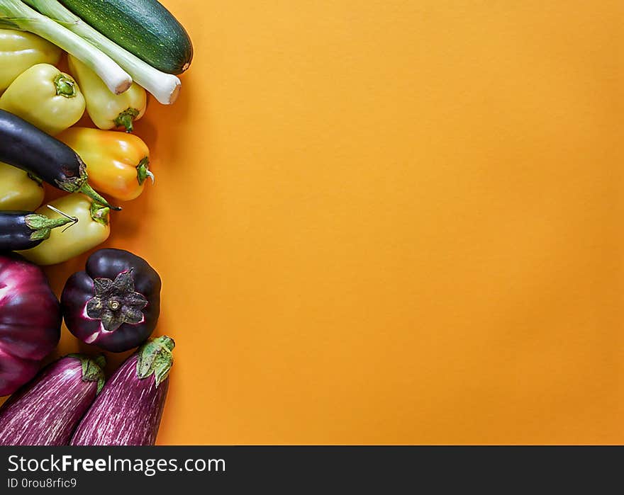 Seasonal vegetables from the garden of orange, green, yellow and purple colors lie freely on a yellow background, top view, copy space, horizontal frame. Seasonal vegetables from the garden of orange, green, yellow and purple colors lie freely on a yellow background, top view, copy space, horizontal frame