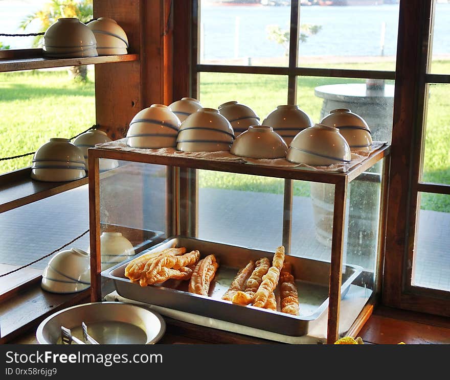 A stall sells Chinese fried breadsticks and bowls of soybean milk. A stall sells Chinese fried breadsticks and bowls of soybean milk