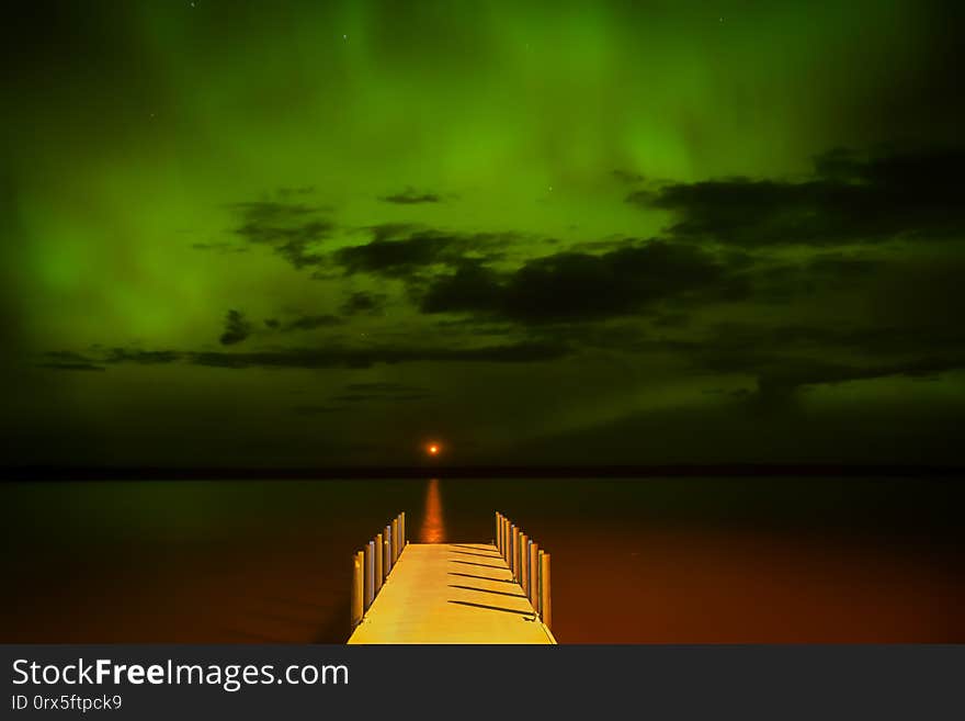 Northern lights over a water pier