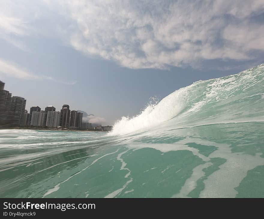 Perfect wave in Rio. Fantastic clouds with a good wave breaking in the beach break of Barra da Tijuca&#x27;s beach,  Rio de Janeiro  - Brazil, tijucas