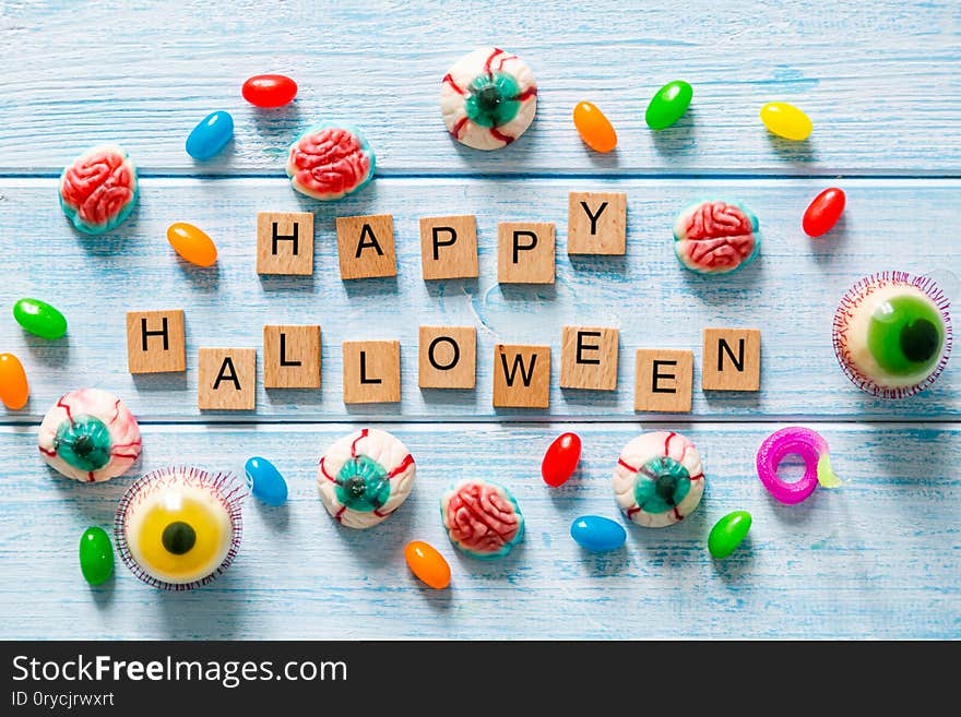 Halloween background - cady and sweets on blue wood background