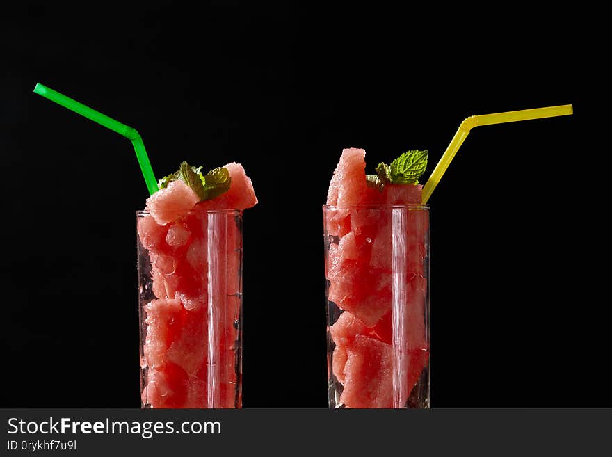 Photo of two glasses with abstract watermelon delicious cocktail on black background. Photo of two glasses with abstract watermelon delicious cocktail on black background