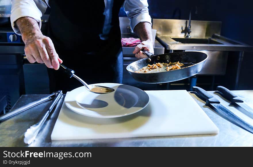 Chef preparing food, meal, in the kitchen, chef cooking, Chef decorating dish, closeup. Chef preparing food, meal, in the kitchen, chef cooking, Chef decorating dish, closeup