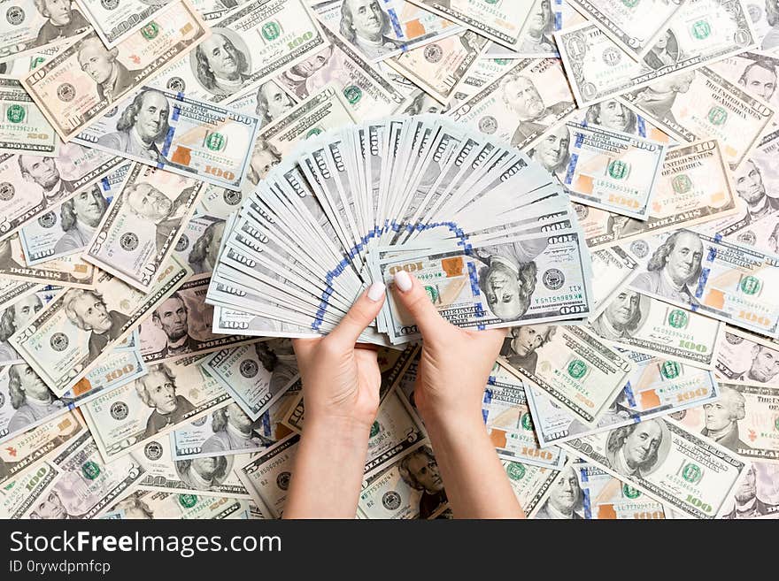 Top view of female hands counting money on different dollar background. Debt concept. Investment concept.