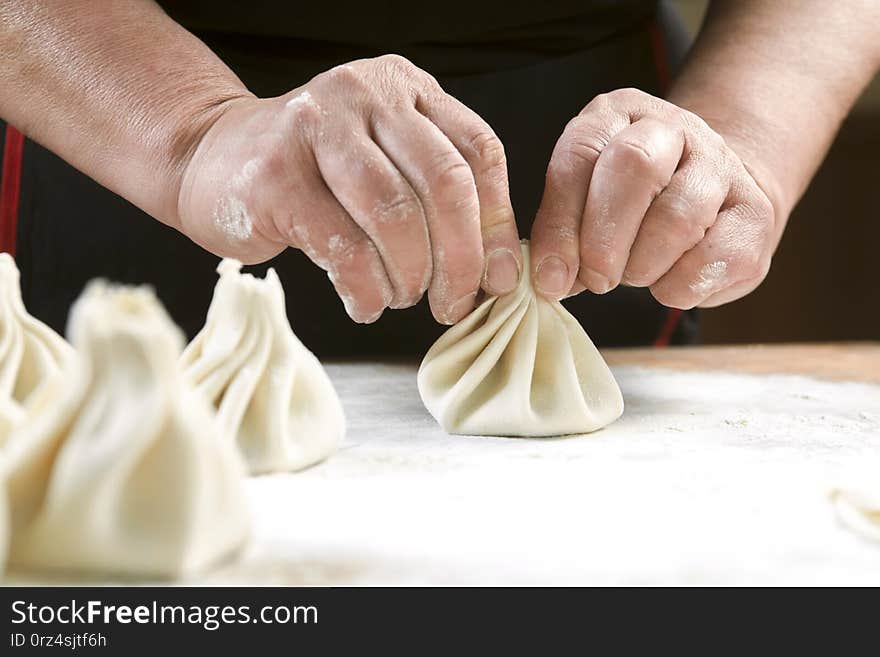 Chef cook making khinkali  on wooden table. Process preparation georgian meal. food concept. Chef cook making khinkali  on wooden table. Process preparation georgian meal. food concept