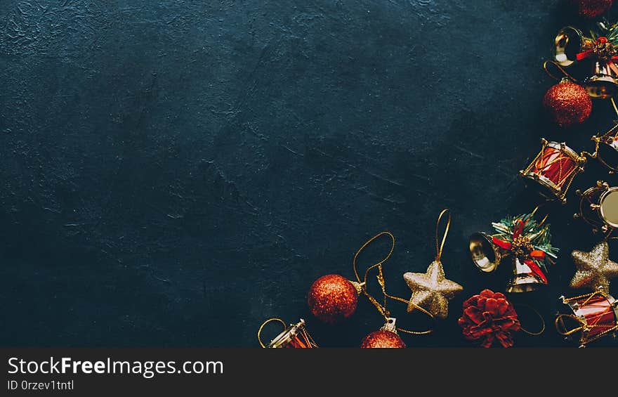 Winter holidays greeting card. Cropped flat lay of Christmas ornaments on dark teal blue background. Copy space. Winter holidays greeting card. Cropped flat lay of Christmas ornaments on dark teal blue background. Copy space.