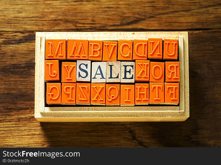 SALE -  abstract in wood type stamps against wooden background and copy space.close up