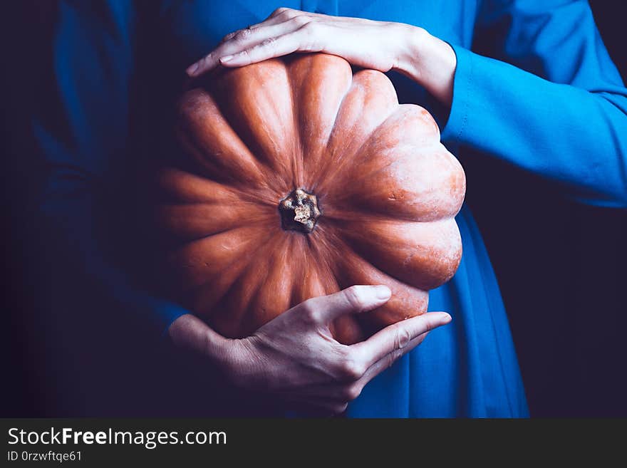 Girl holding beautiful aesthetic pumpkin on a black background. Halloween. Girl holding beautiful aesthetic pumpkin on a black background. Halloween