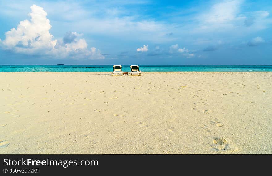 Along the azure sea there are sun loungers for visitors to relax. Maldives, the concept of family vacations, tourism. Along the azure sea there are sun loungers for visitors to relax. Maldives, the concept of family vacations, tourism.