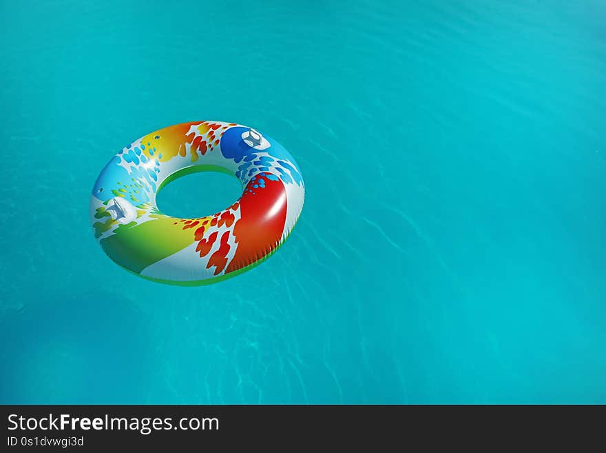 Colorful inflatable ring floating in swimming pool on sunny day. Space for text