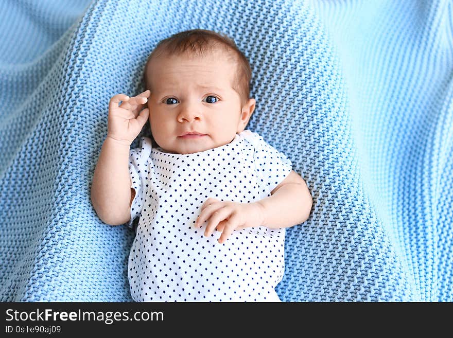 Cute little baby lying on light blue d, top view