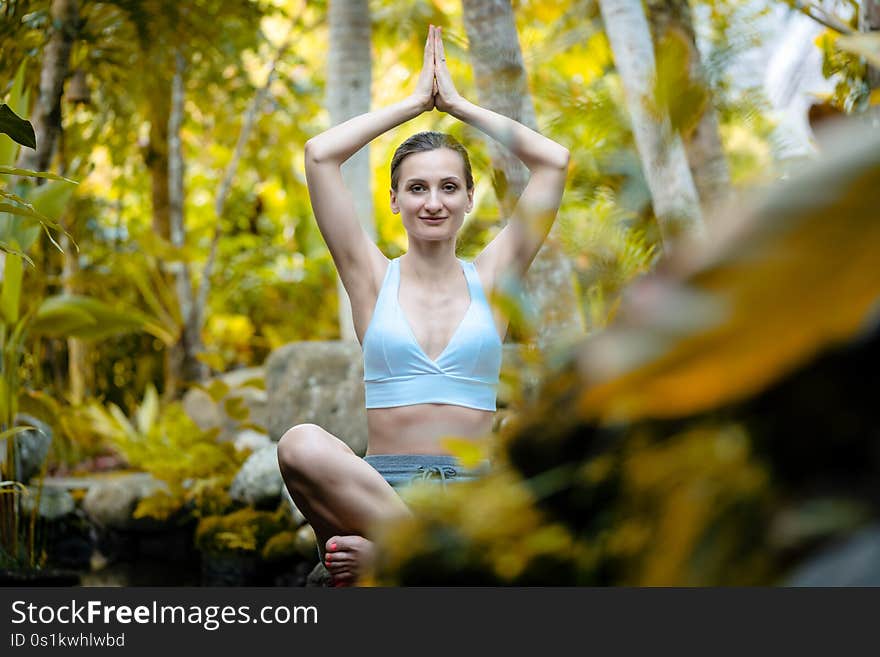 Woman doing yoga in the tropical jungle