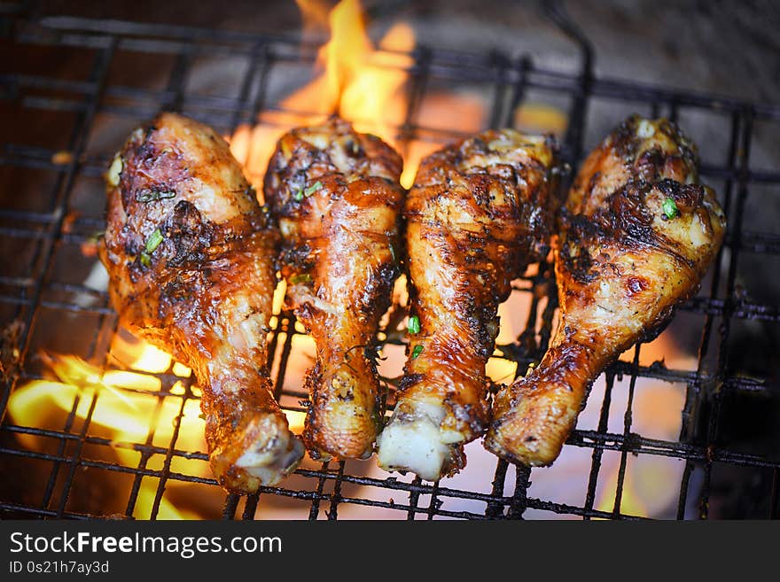 Grilled chicken legs barbecue with herbs and spices top view / Tasty chicken legs on the grill with fire flames marinated with ingredients cooking. Grilled chicken legs barbecue with herbs and spices top view / Tasty chicken legs on the grill with fire flames marinated with ingredients cooking