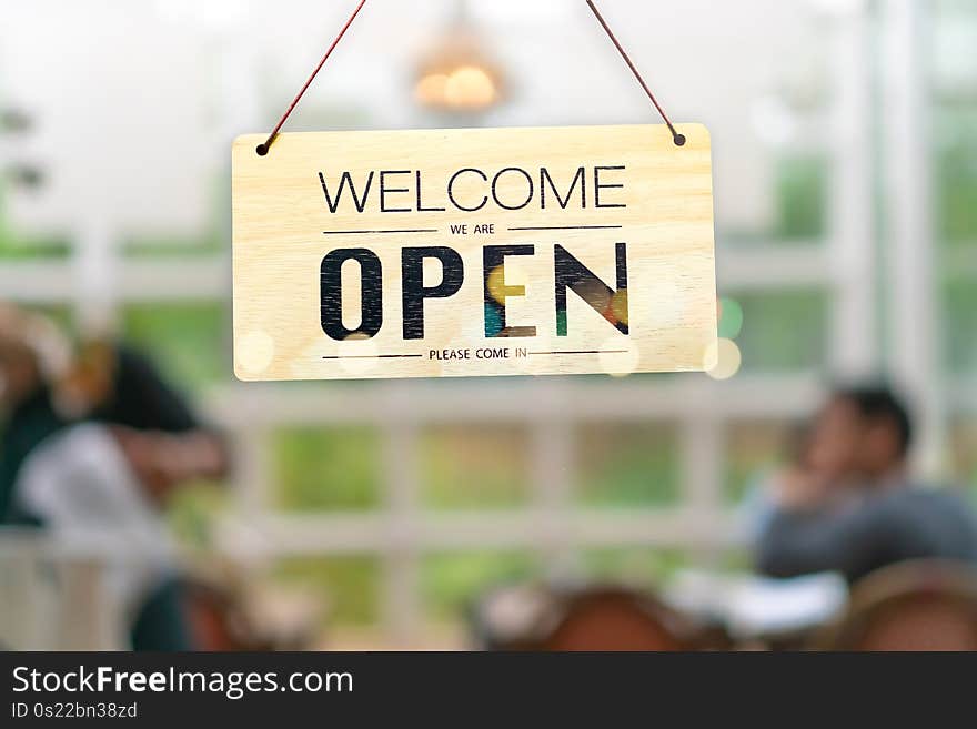 A business sign that says open on cafe or restaurant hang on door at entrance