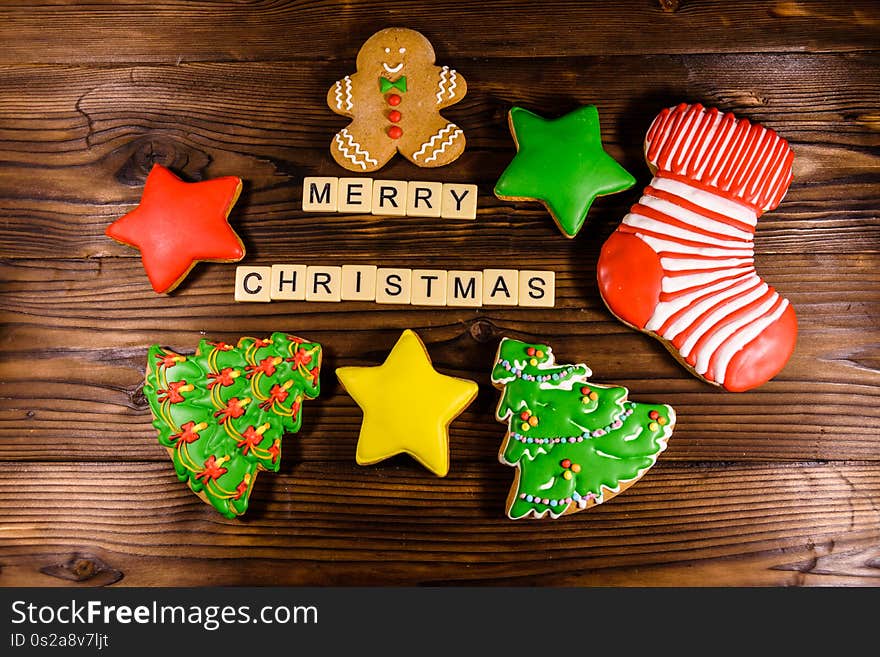 Different christmas gingerbread cookies on wooden table. Top view. Merry Christmas inscription