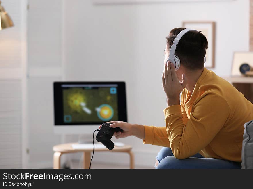 Young man playing video games at home