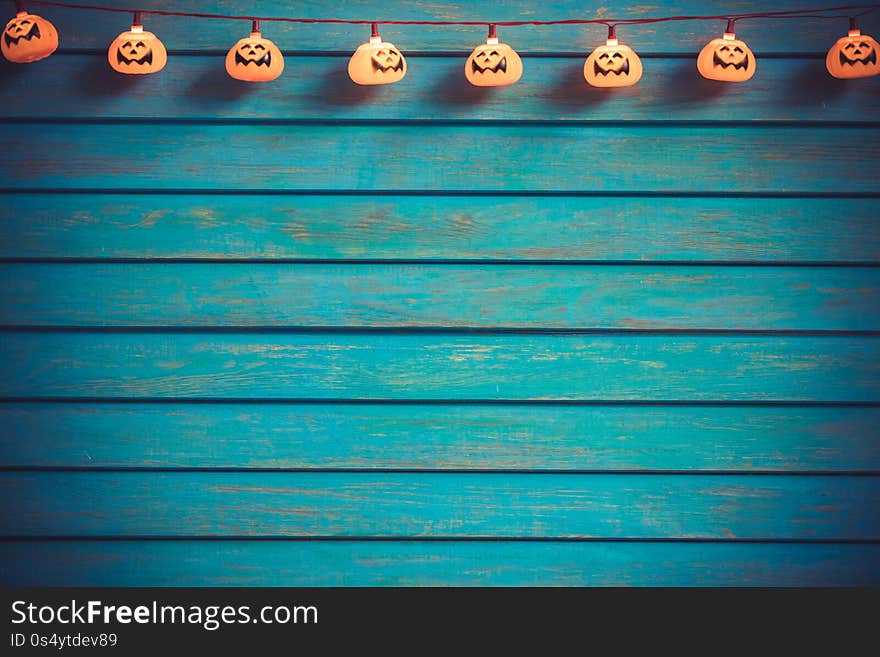 Scary pumpkin garland against wooden background. Happy Halloween concept. Scary pumpkin garland against wooden background. Happy Halloween concept