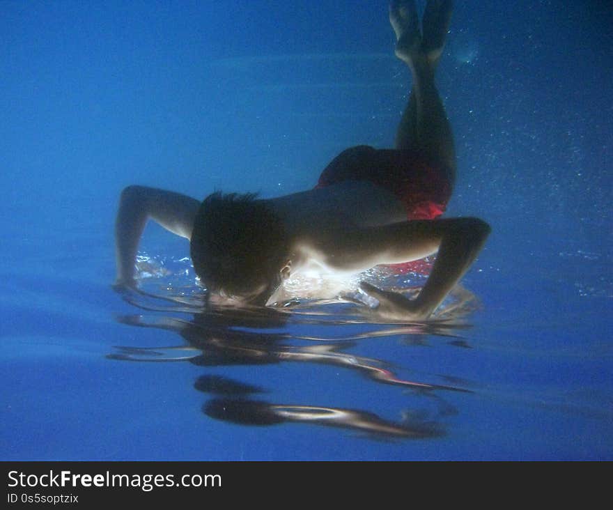A beautiful shot of a kid swimming underwater