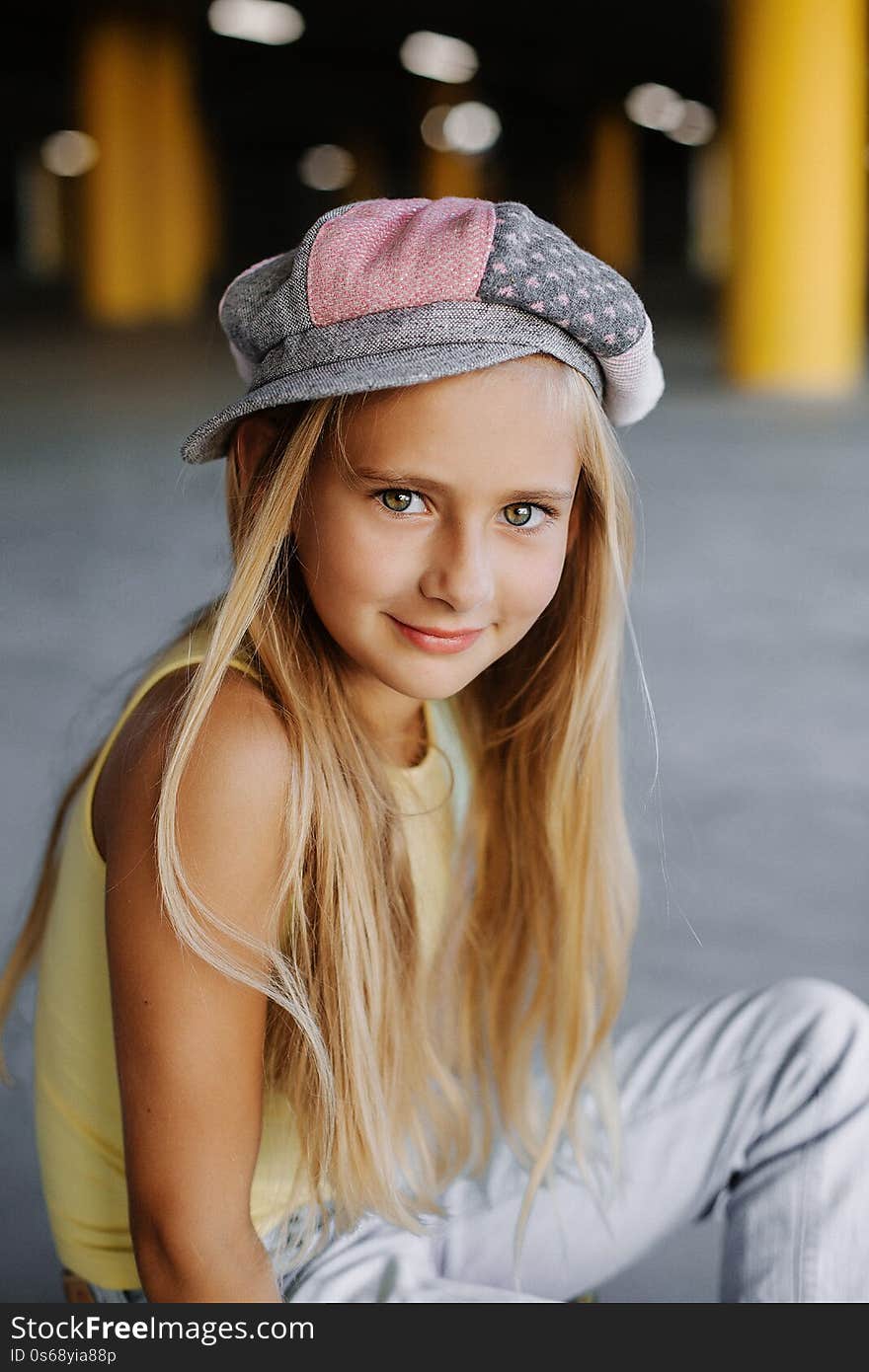 Portrait of a beautiful girl with long blond hair in hat