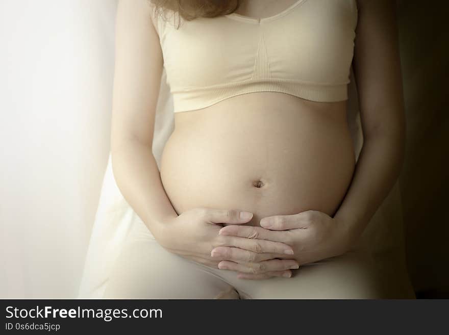 Close up of pregnant woman with her arms on her belly. Close up of pregnant woman with her arms on her belly.