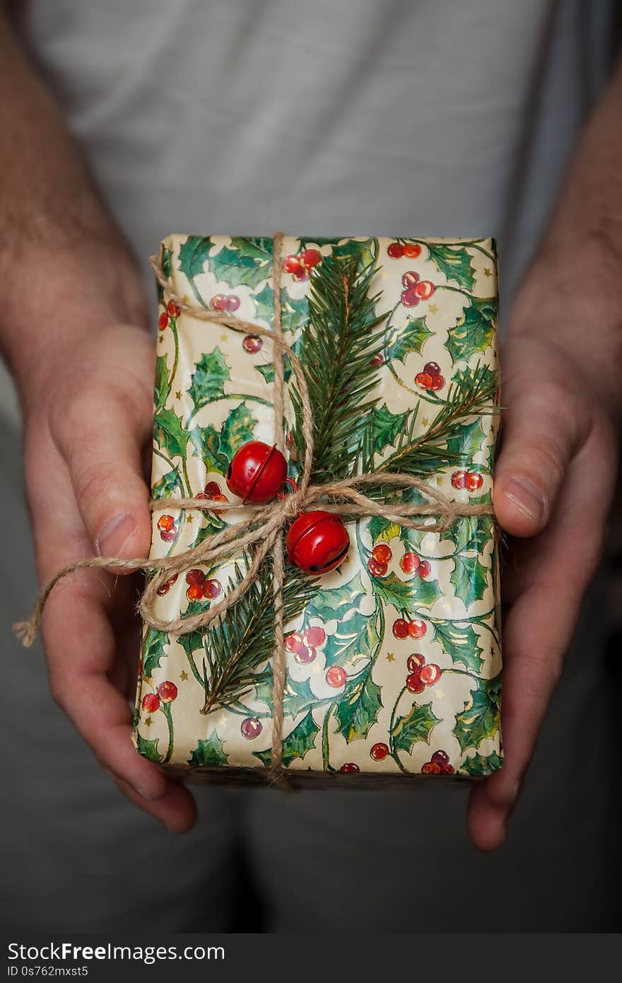 Wrapped New Year`s gifts with fir and cones and bells in hands. Life style