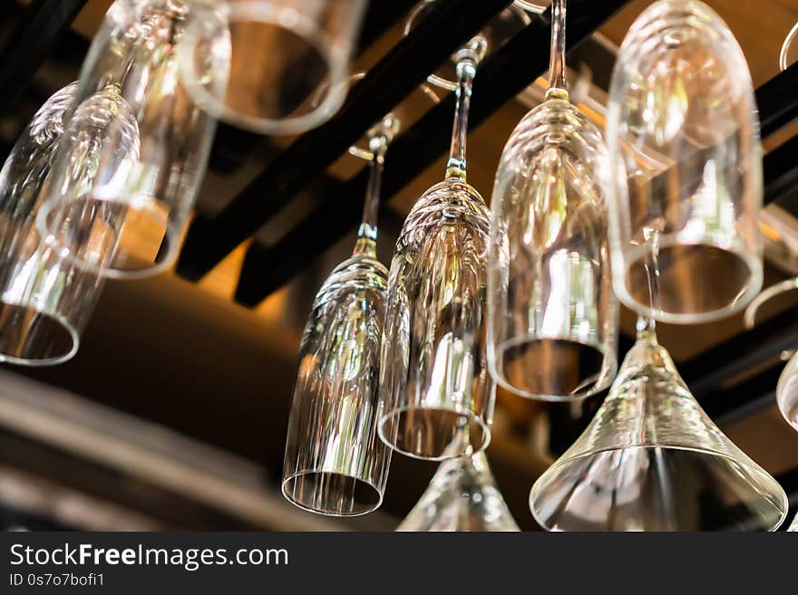 A lot of champagne glass hanging on a rack with blurred background