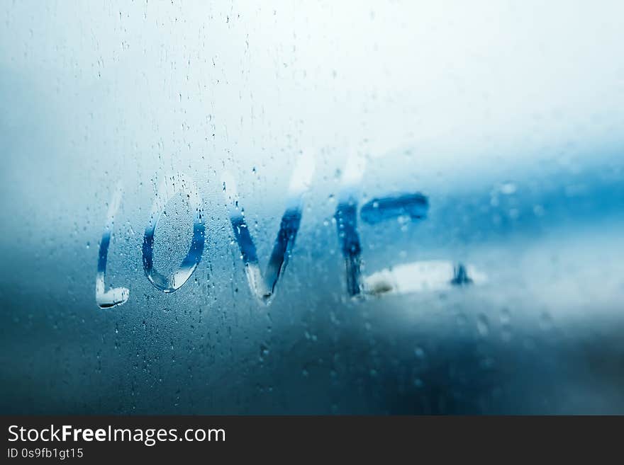 Women Hand`s Drawing LOVE Word On Glass Window With Water Drop Concept Design For Valentine`s Day Or Wedding Background