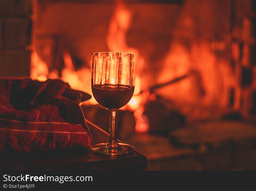 A cup of wine and a pizza dough next to a fireplace. Warm enviroment and warm colors. A cup of wine and a pizza dough next to a fireplace. Warm enviroment and warm colors.