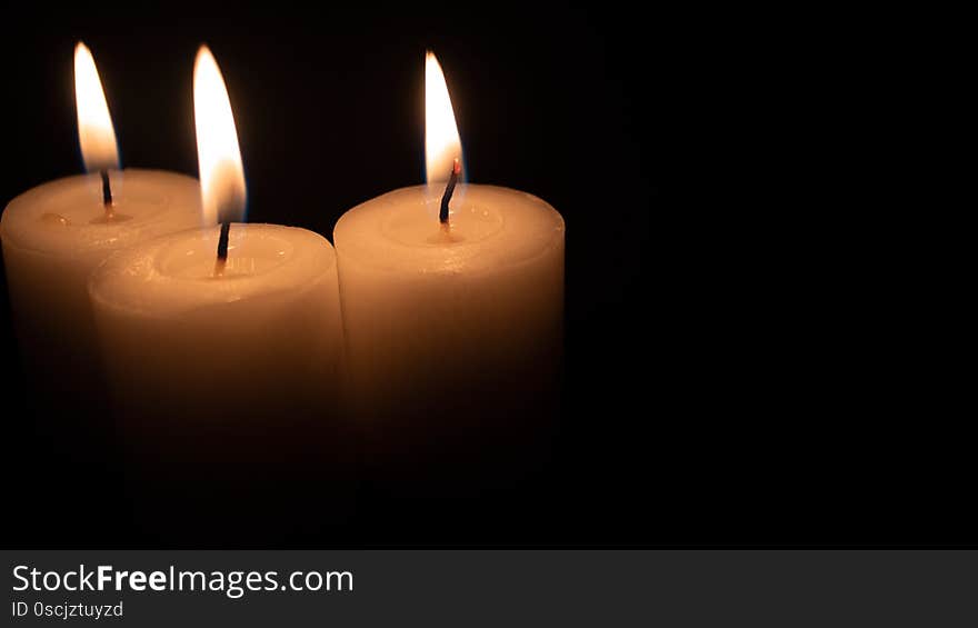 Burning candles on a black background with space to put any text