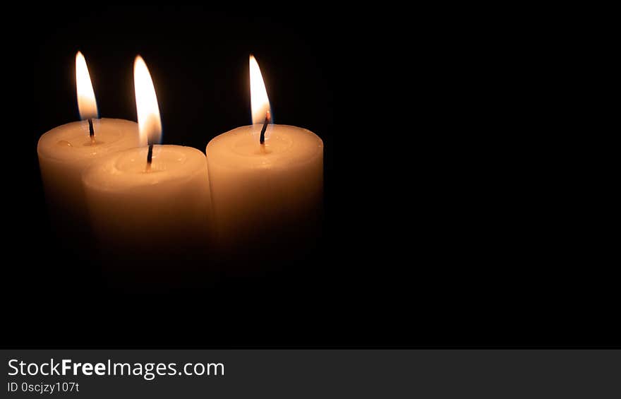 Burning candles on a black background with space to put any text