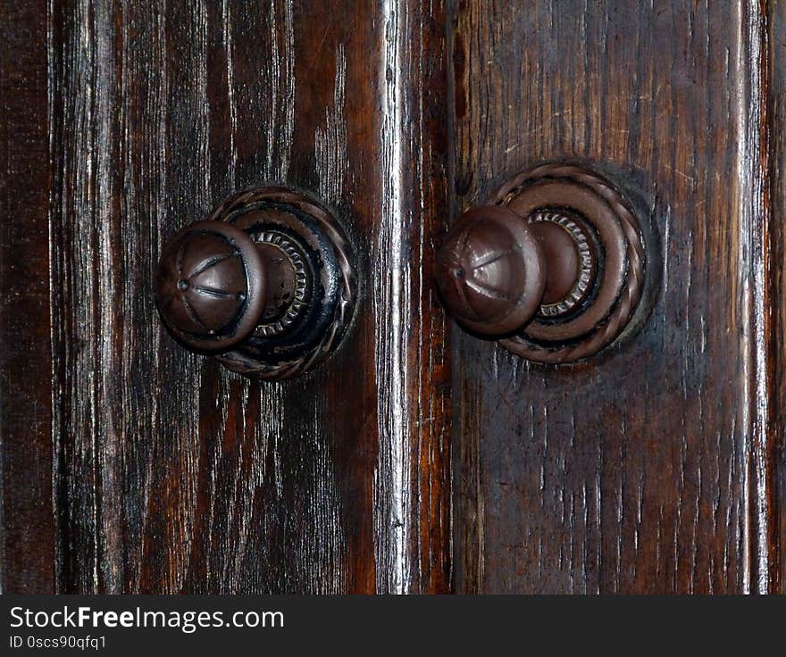 old oak wooden door with worn metal door knob and handle