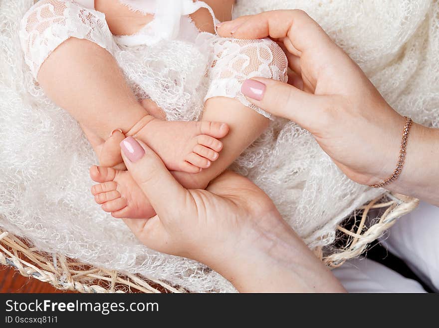 Happy family concept. Newborn baby feet in mother hands in white background.  Mother gently holding legs of a newborn child  in hands. Close up image