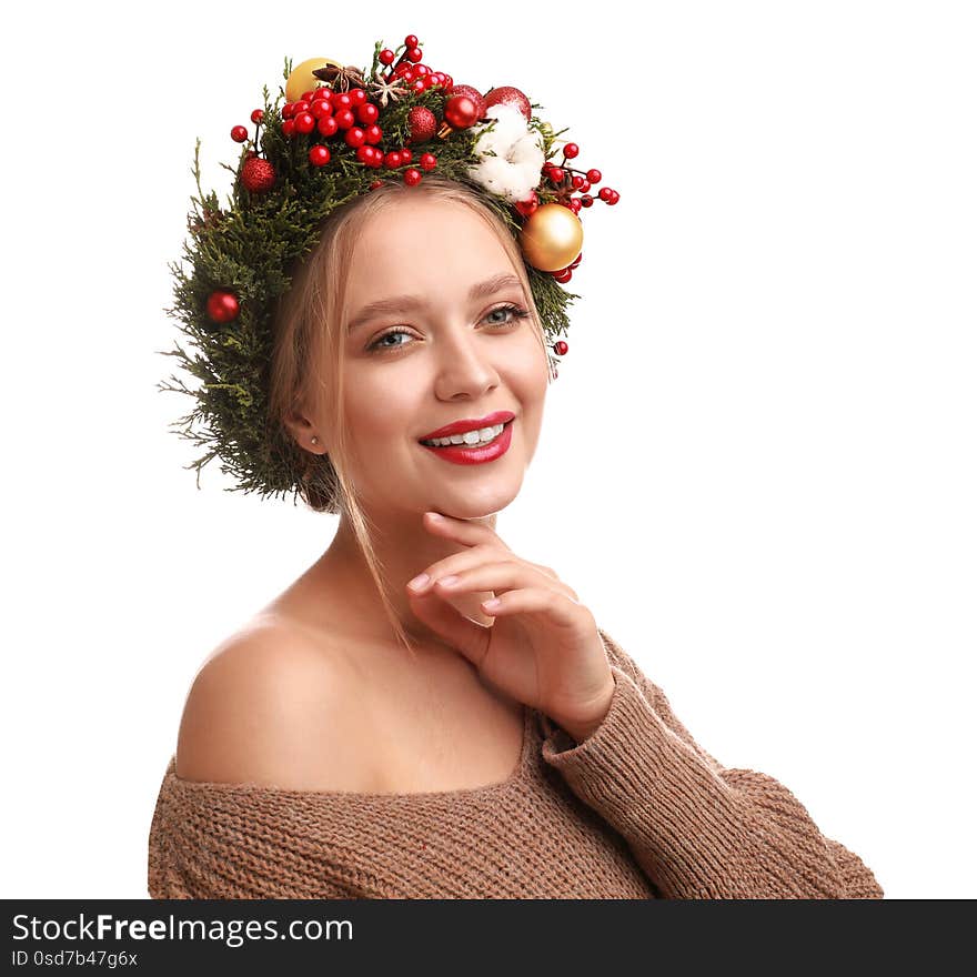 Beautiful young woman wearing Christmas wreath on white background