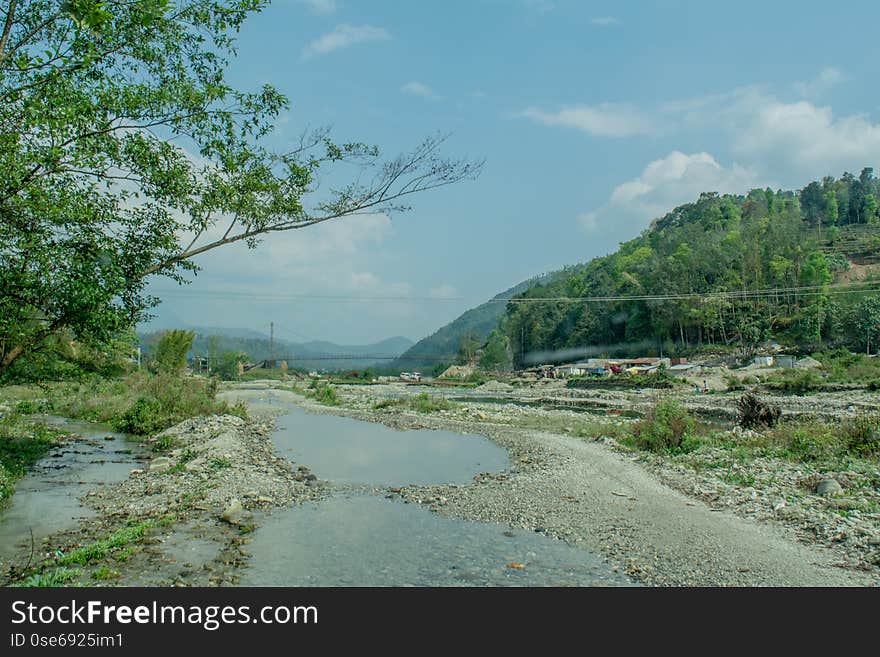 Beautiful landscape of muddy flooded road on the way up into mountains in Nepal