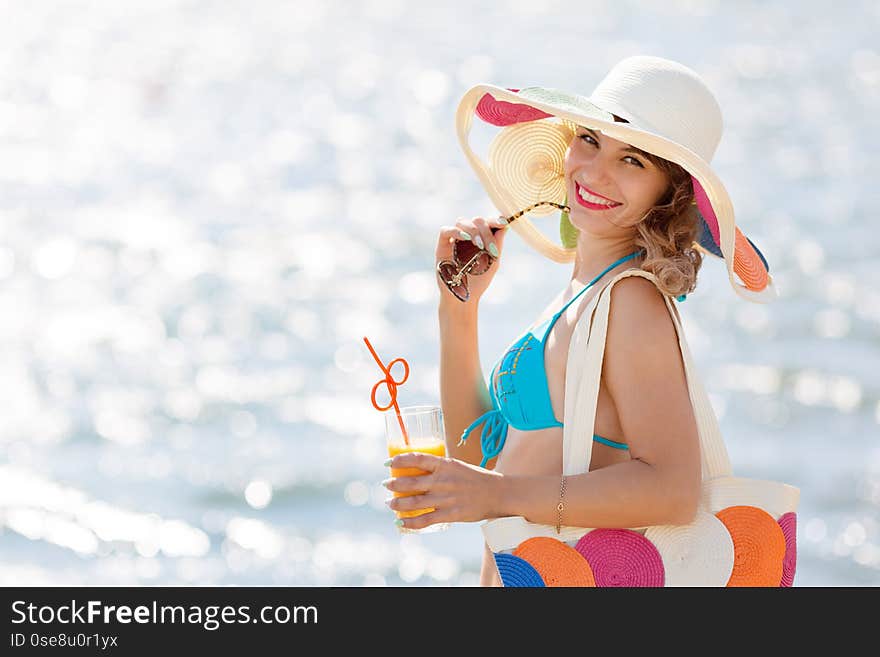 Girl in a hat blue bikini and a glass of juice on vacation. Girl in a hat blue bikini and a glass of juice on vacation