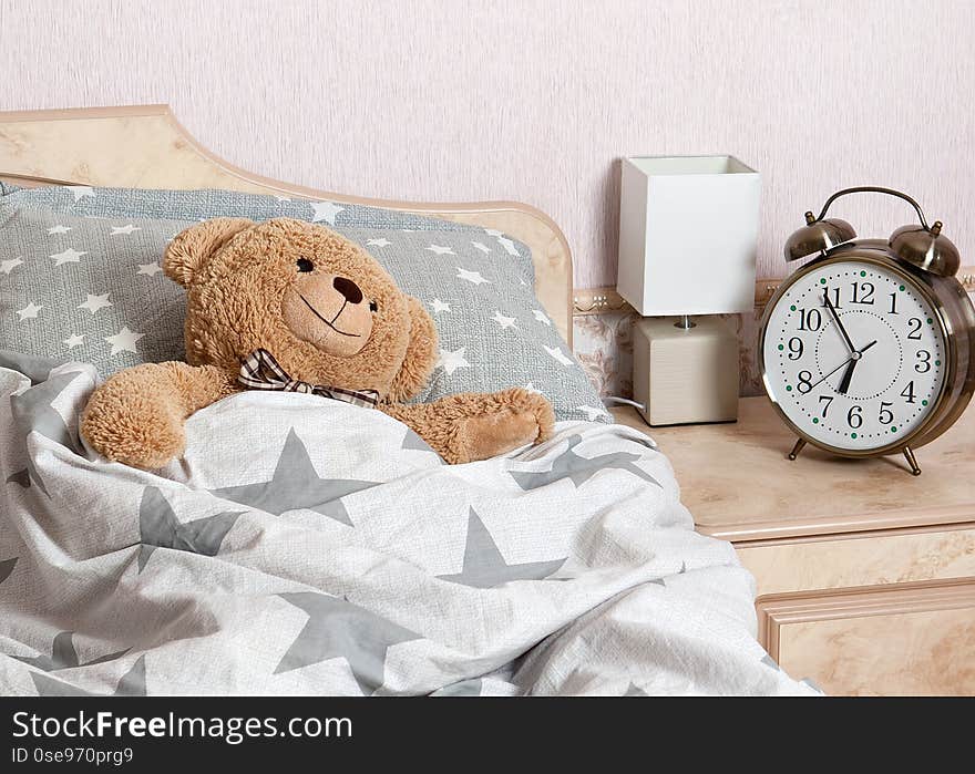 A Teddy bear sleeping in the bed in the bedroom