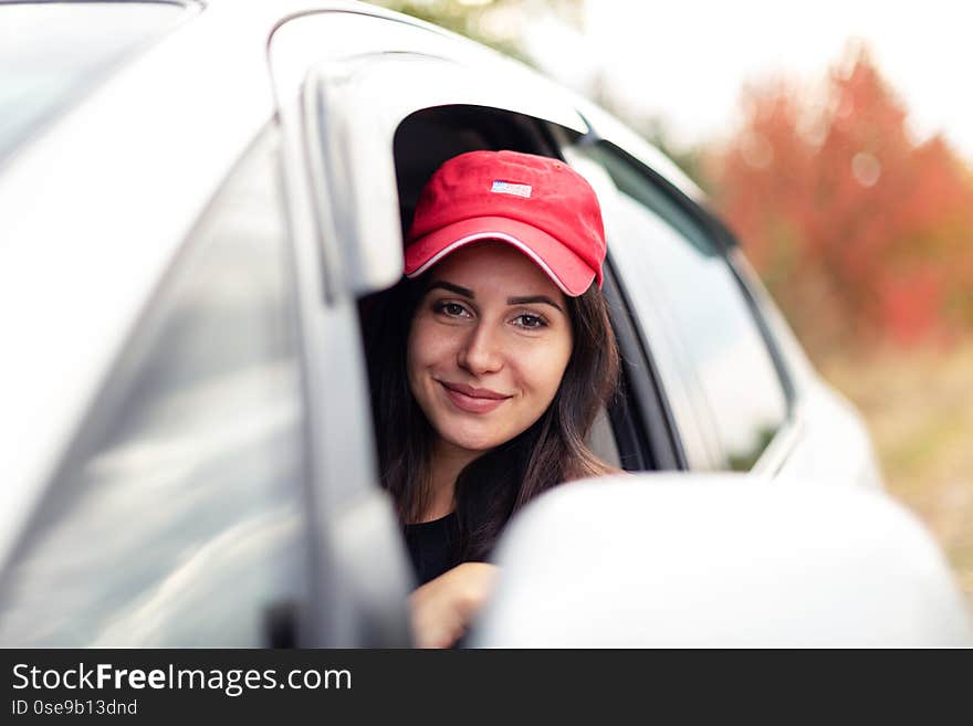 Beautiful smiling girl driving with open window