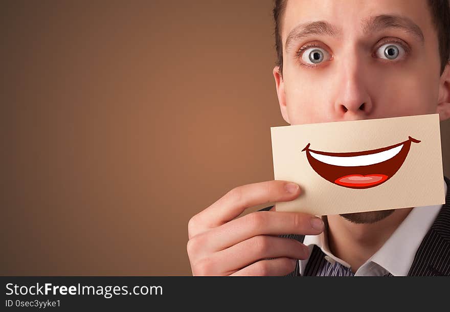 Person holding card in front of his mouth with ironic smile