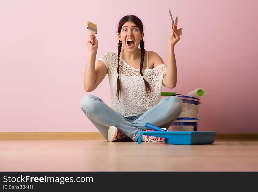 Woman with brush and color palette sitting on the floor