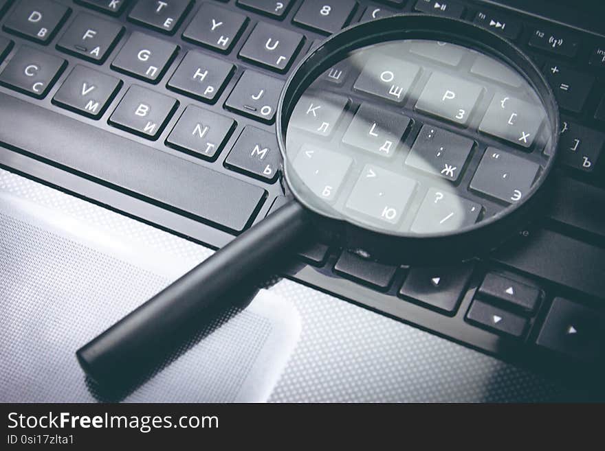 Magnifying glass on black keyboard