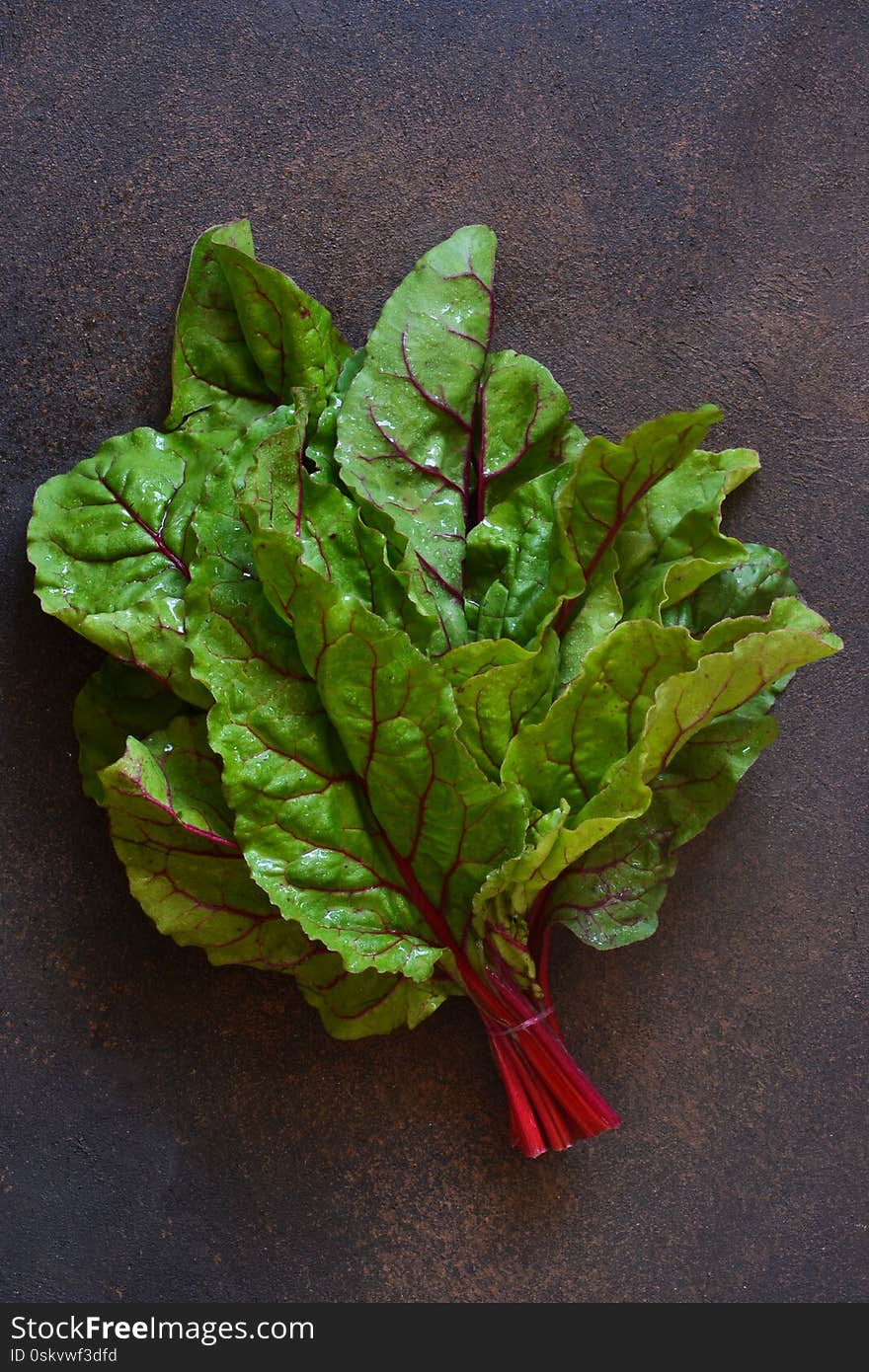 Fresh, raw leaves of the beetroot on a concrete background. Food background