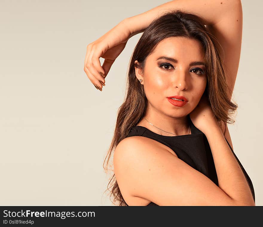 Close-up portrait of beautiful sexy young woman with long brown hair over brown background. With copy space. Fashion Photo shoot