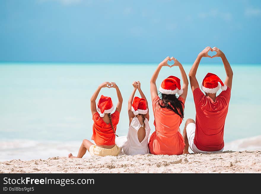 Happy family with two kids in Santa Hat on summer vacation