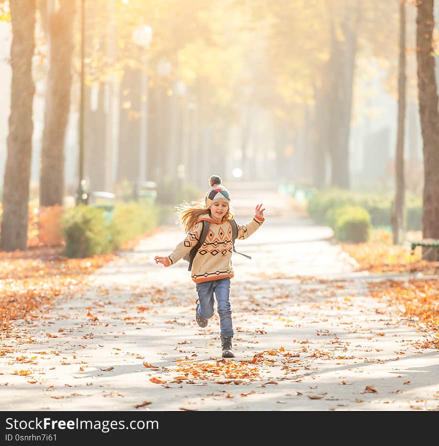 Pretty schoolgirl running in park after classes