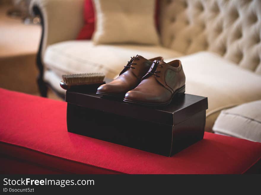 Casual  brown leather male shoes placed on a cardboard box in a nice room. Casual  brown leather male shoes placed on a cardboard box in a nice room.