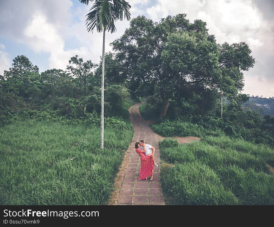 Young couple posing on the road in the jungle of Bali island. Indonesia.