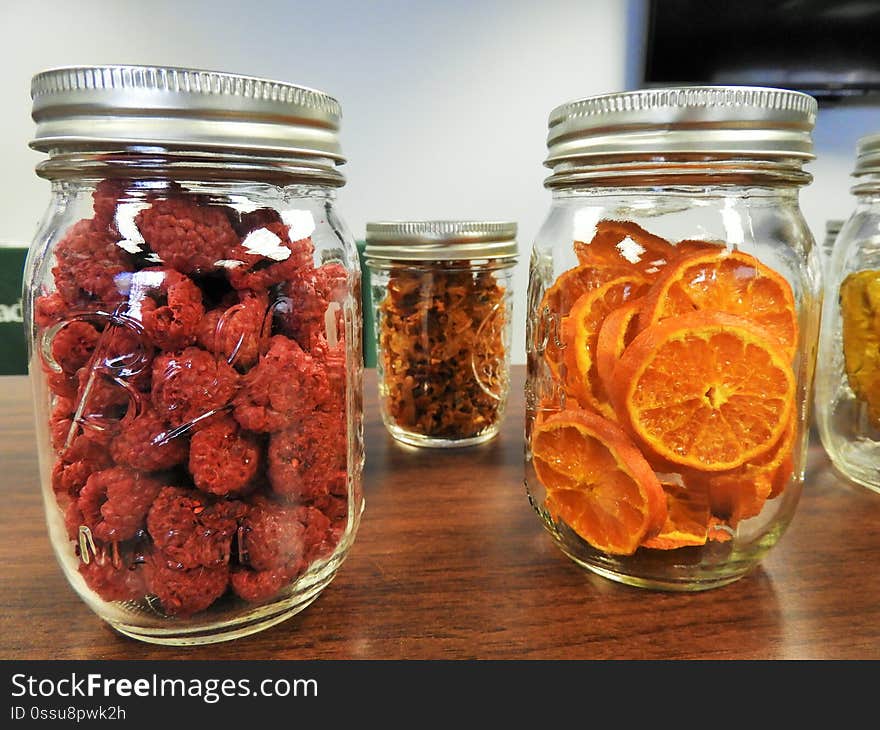 Mason jars with dehydrated raspberries and oranges