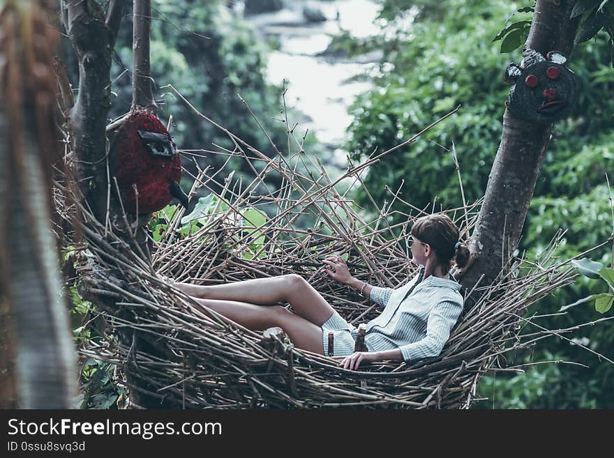 Young woman relaxing in the jungle of Bali island.