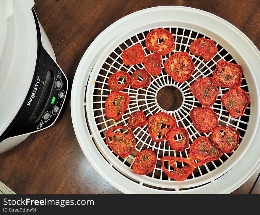 Dried tomato slices near dehydrator